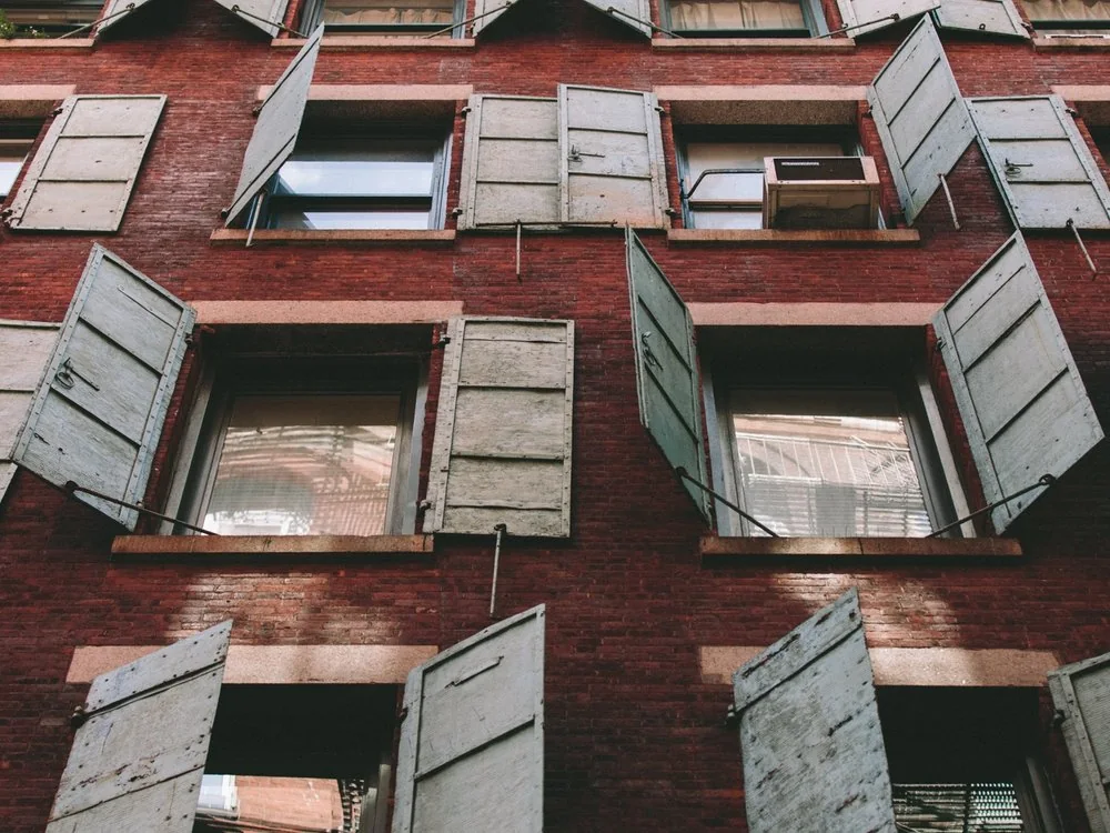 Red brick facade with open window shutters in New York